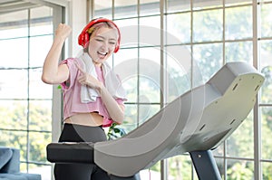 Asian young pretty cheerful happy healthy fitness girl in sexy sportswear with headphones listening to music playlist walking