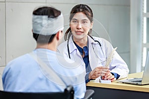 Asian young professional female practitioner doctor in white lab coat with stethoscope holding skull model showing explaining to
