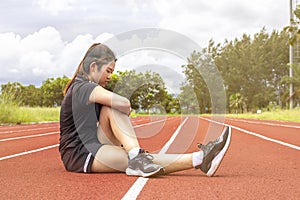 Asian young sportswoman warm up before exercise on running on race track outdoor sports field