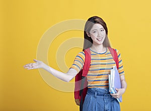 asian young student holding books and showing something