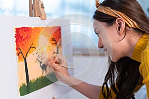 Asian young talented woman artist coloring on painting board in house. Attractive beautiful female draw art picture, creating