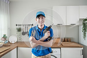 Asian young Technician service man wearing blue uniform checking electrical appliances in home