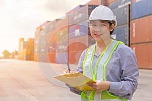 Asian young teen happy worker checking stock in shipping port work manage import export cargo containers