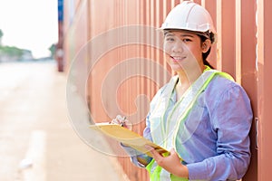 Asian young teen happy worker checking stock in shipping port work manage import export cargo containers