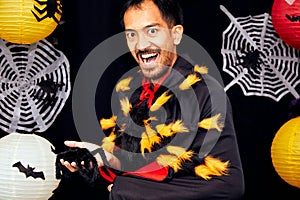 Asian young wizard Halloween man portrait and black spider on chest close up with copy space