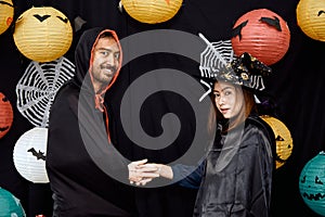 Asian young wizard Halloween man portrait standing with witch Halloween woman shaking hand