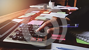 Asian young woman in black suit working calculate tax lead to liquidation with Sunset light vintage style