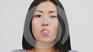 Asian Young Woman Chewing And Blowing Bubble-Gum, White Background