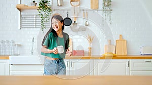 Asian young woman dancing in kitchen room