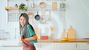 Asian young woman dancing in kitchen room