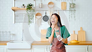 Asian young woman dancing in kitchen room