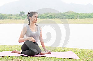 Asian young woman doing yoga practice on health park background