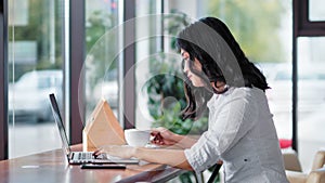 Asian young woman drinking coffee using laptop having relaxing time