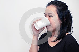 Asian young woman drinking a fresh white paper cup of water or other beverage