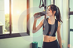 Asian young woman drinking protein shake or water after exercise