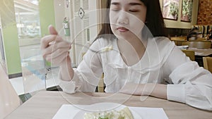 Asian young woman enjoy eating healthy food vegetable salad in restaurant background