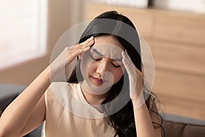 Asian young Woman has a Migraine and headache after wake up in cozy bedroom at home,Suddenly of painful attack on head massage