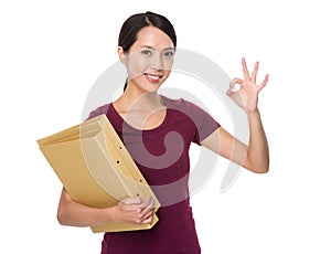 Asian young woman hodling with folder and ok sign gesture