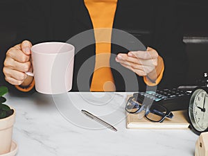 Asian young woman holding coffee cup and using smartphone shopping online-calculate home salary and expenses. concept saving money