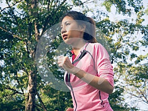 Asian young woman on mark to set ready for jogging exercise to build up her body on glass in warm light morning.