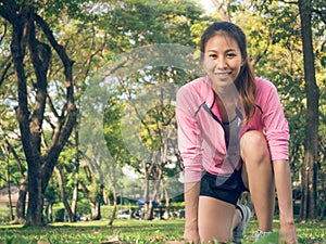 Asian young woman on mark to set ready for jogging exercise to build up her body on glass in warm light morning.