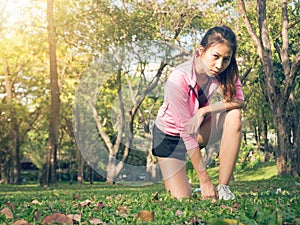 Asian young woman on mark to set ready for jogging exercise to buld up her body on glass in warm light morning.