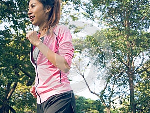 Asian young woman on mark to set ready for jogging exercise to buld up her body on glass in warm light morning.