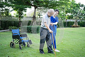 Asian young woman nurse at nursing home take care disabled senior man. Caregiver doctor serve physical therapy for older elderly