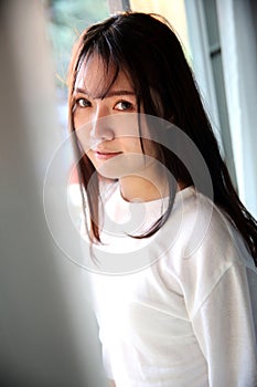 Asian young woman portrait in bed room with white tone