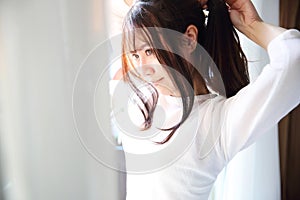 Asian young woman portrait in bed room with white tone