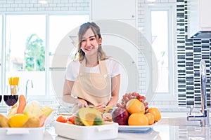 Asian young woman prepare to cooking dinner in kitchen. Food and Drinks concept. Beauty and Single mom concept. Happy life and