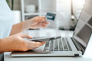 Asian young woman resting and browsing internet with Laptop holding credit card online shopping concept