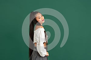 Asian young woman's portrait isolated over color studio background with copyspace