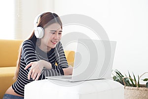 Asian young woman satisfied with learning language of online courses with laptop,