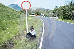 Asian young woman sit on the side of the road