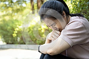 Asian young woman sitting alone in outdoor at park, broken heart despair, suffer depression problem, feeling sad,cry,disappointed