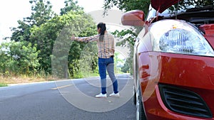 Asian young woman stopping a car and needs a help with her broken car on road