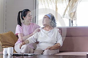 Asian young woman take care and support with hug, that make feel good and smile older mother in living room. family concept