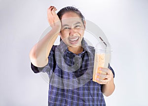 Asian young woman touching head with hand because she Brain freeze from drinking cold water. Health care concept