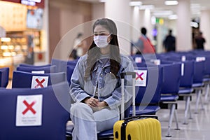 Asian young woman traveller wearing face maks at airport Due Covid-19 flu virus pandemic photo