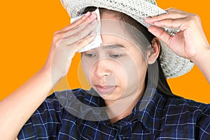 Asian young woman uses a tissue to wiped the sweat on her forehead on a hot day photo