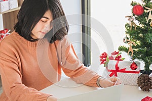 Asian young woman using laptop computer and holding credit card for christmas online shopping