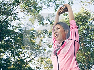 Asian young woman warm up the body stretching before morning exercise and yoga in the park under warm light morning. photo