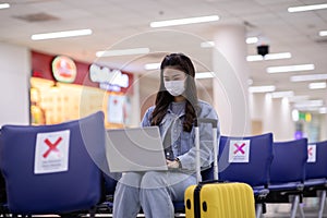 Asian young woman wearing face maks holding passport and boarding pass at airport photo