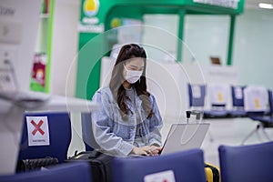 Asian young woman wearing face maks holding passport and boarding pass at airport Due Covid-19 flu virus pandemic photo