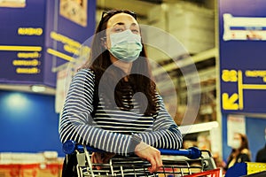 Asian young woman wearing a hygiene protective mask over her face while walking at the crowded shopping mall. influenza in