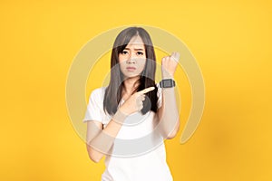 Asian young woman wearing white t-shirt standing. She looking on smart watch on hand