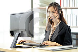 Asian young woman working in call centre. Young friendly operator woman agent with headsets working in a call centre