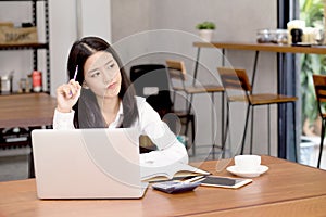 Asian young woman working online with laptop and think project