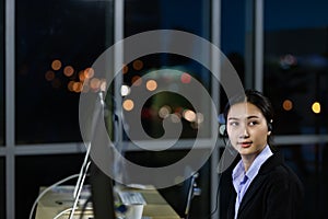 Asian young woman working overtime late at night in call center office